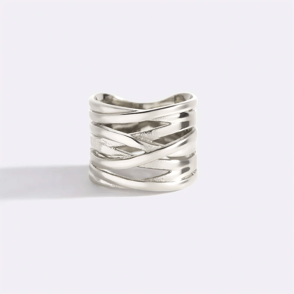 Silver ring with crisscross design on a light gray background