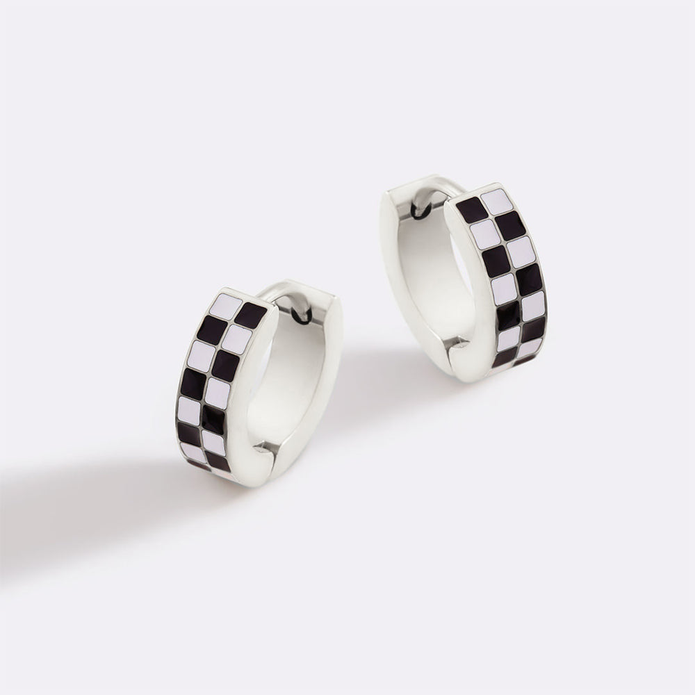 Pair of silver hoop earrings with black and white checkered pattern on a white background