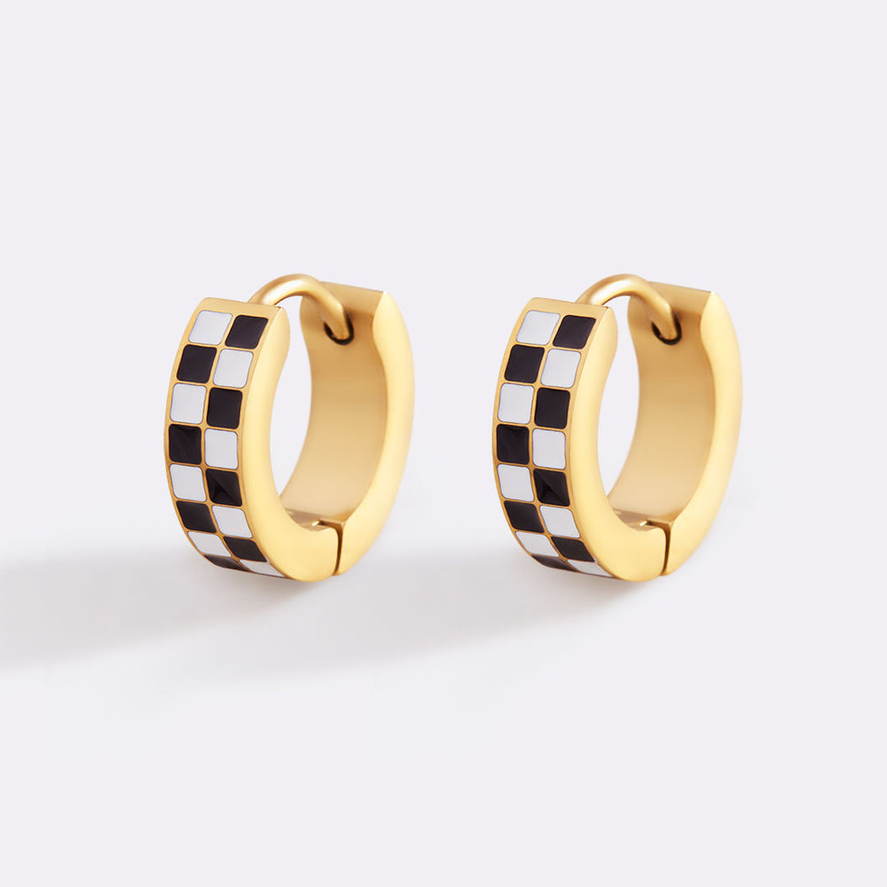 Gold hoop earrings with black and white checkered design on a light gray background