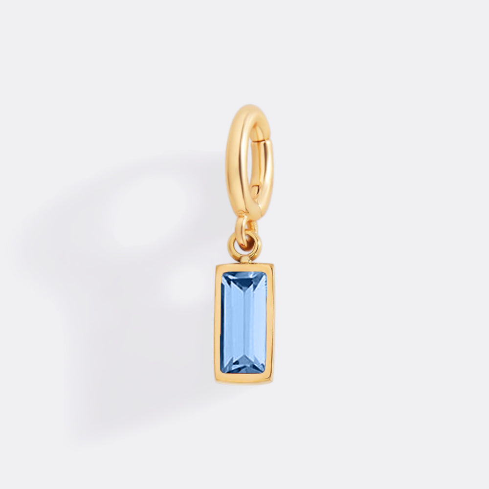 Gold pendant with a blue gemstone on a white background
