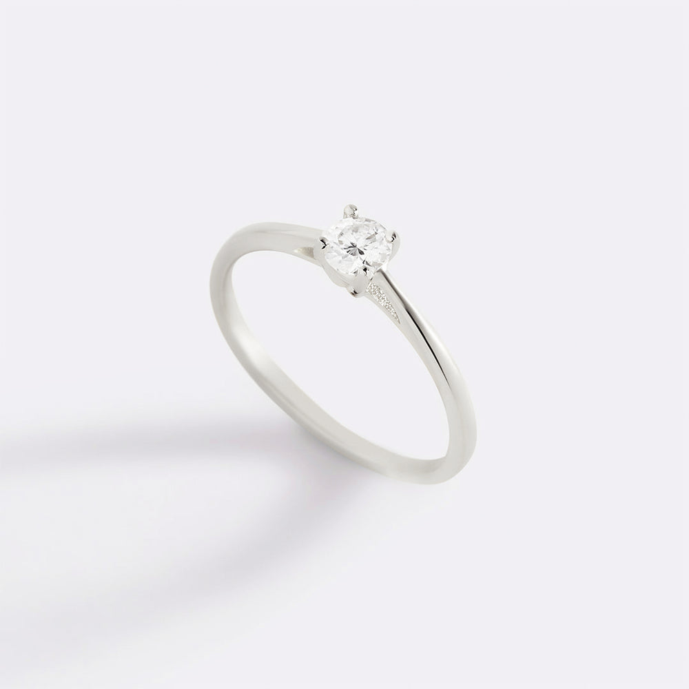 A gold solitaire ring with a single sparkling diamond set in a prong setting.