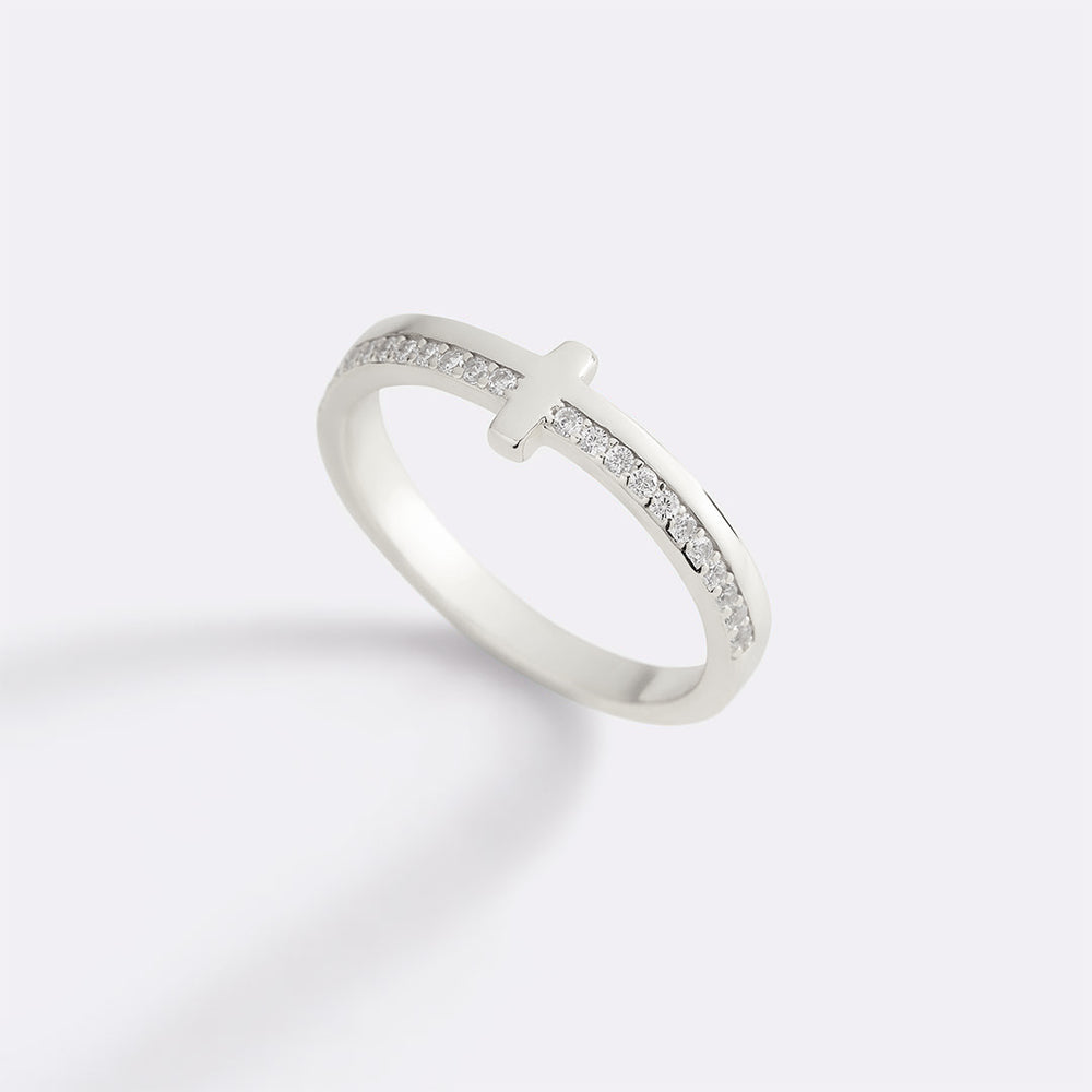 Silver ring with a cross design on a light gray background