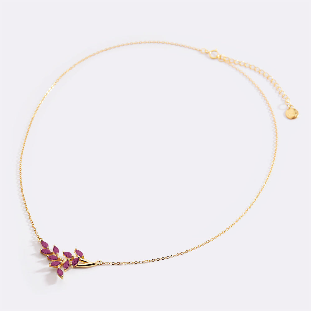 Gold necklace with pink gemstones on a white background