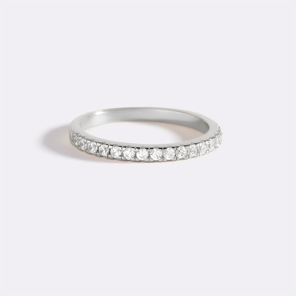 Silver ring with small diamonds on a light gray background
