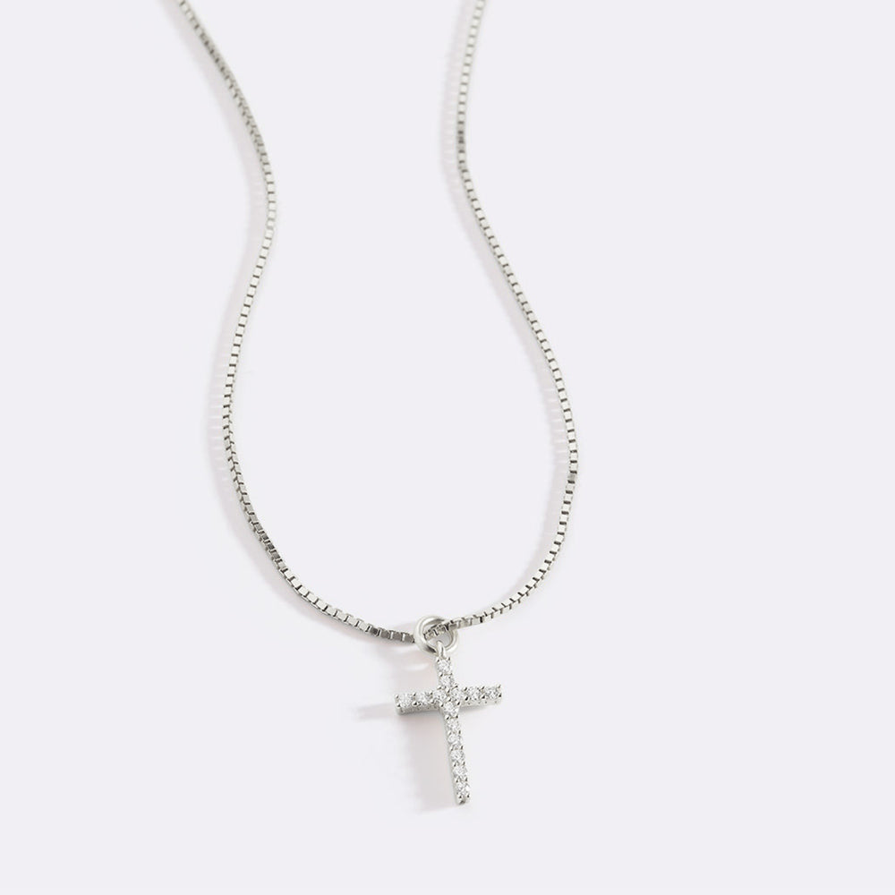 Silver cross necklace on a white background