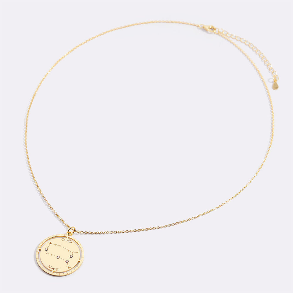 Gold necklace with a circular pendant on a light gray background