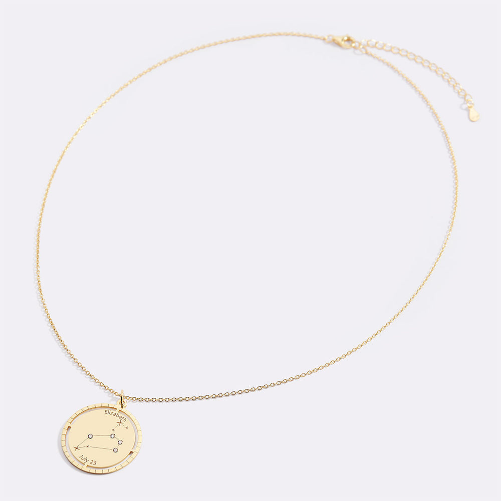 Gold necklace with a round pendant on a light gray background