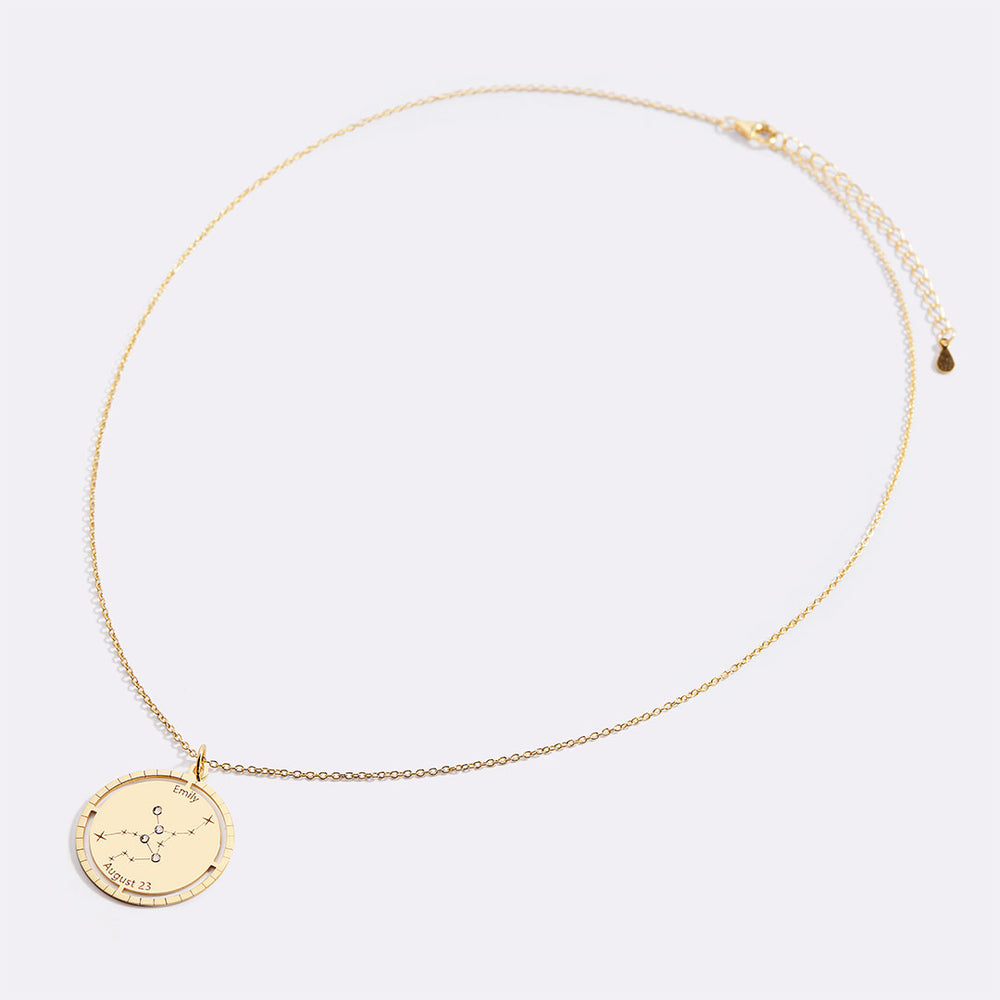 Gold necklace with a round pendant on a light gray background