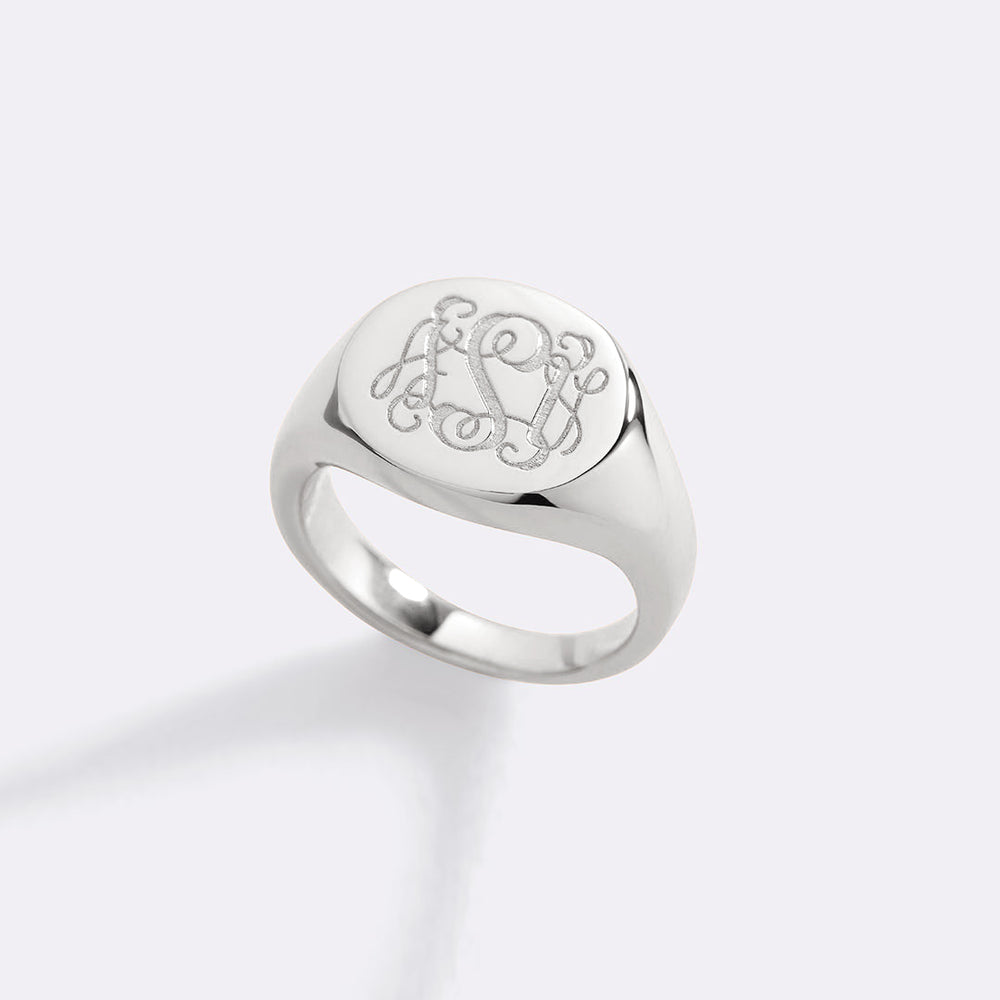 Silver ring with engraved monogram on a white background