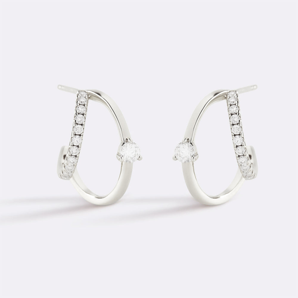 Pair of silver hoop earrings with embedded stones on a light gray background
