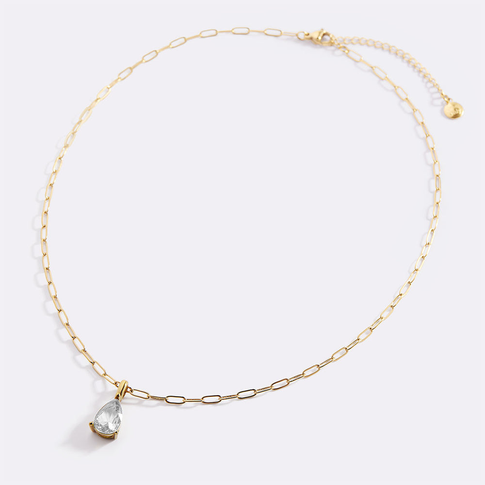 Gold necklace with a teardrop-shaped pendant on a light gray background