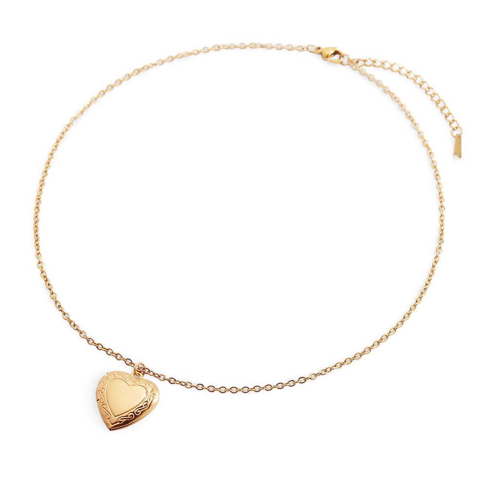 Gold necklace with heart-shaped pendant on a light gray background