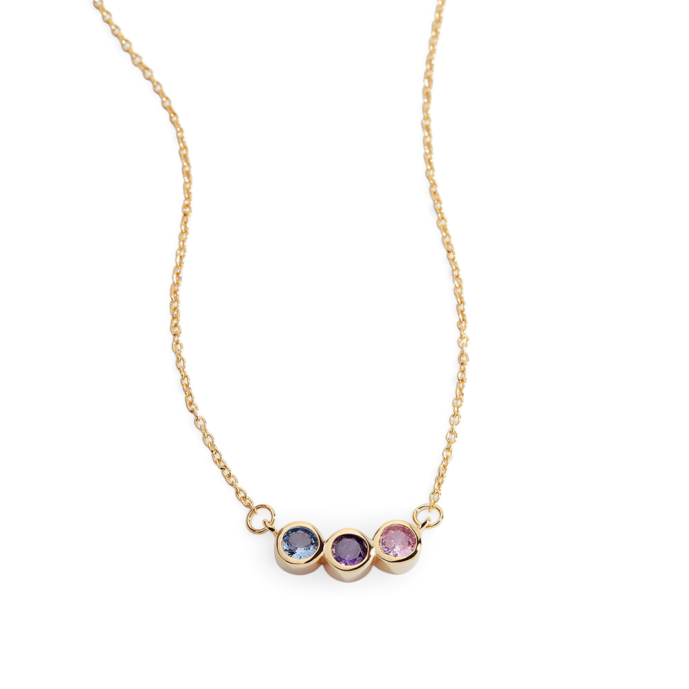 A dainty gold-colored necklace featuring a series of round charms with multicolored birthstones on a black background.