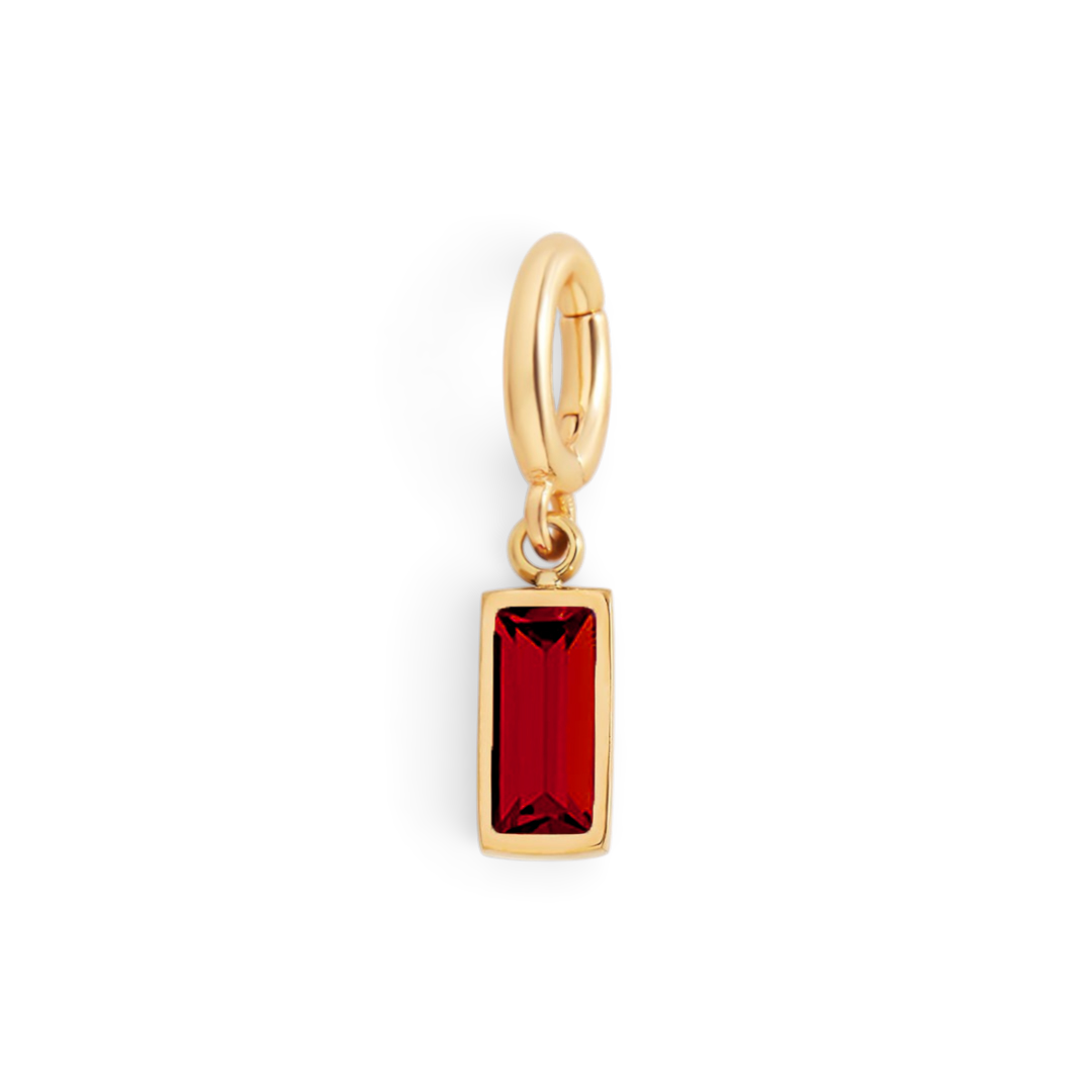 Gold pendant with a red gemstone on a white background