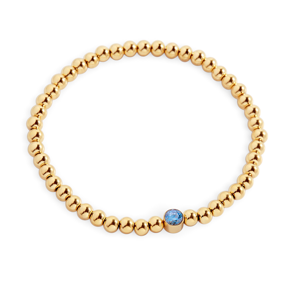 Gold beaded bracelet with a blue gemstone on a white background