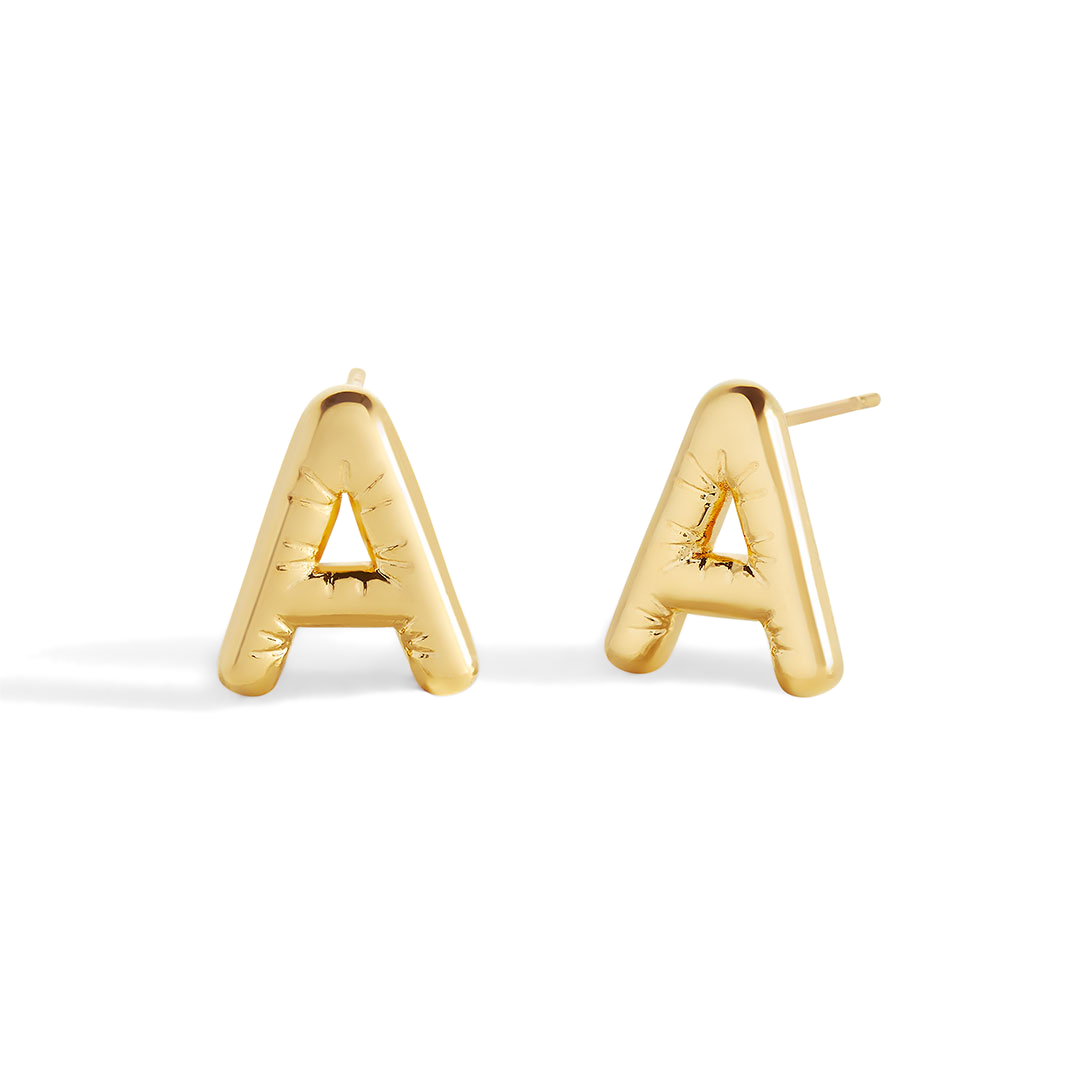 A pair of gold-colored balloon-shaped earrings against a black background.