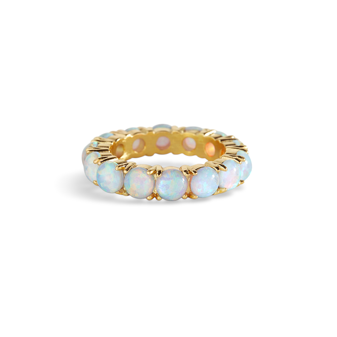 A gold-colored eternity ring featuring a series of blue opal stones set along its band.