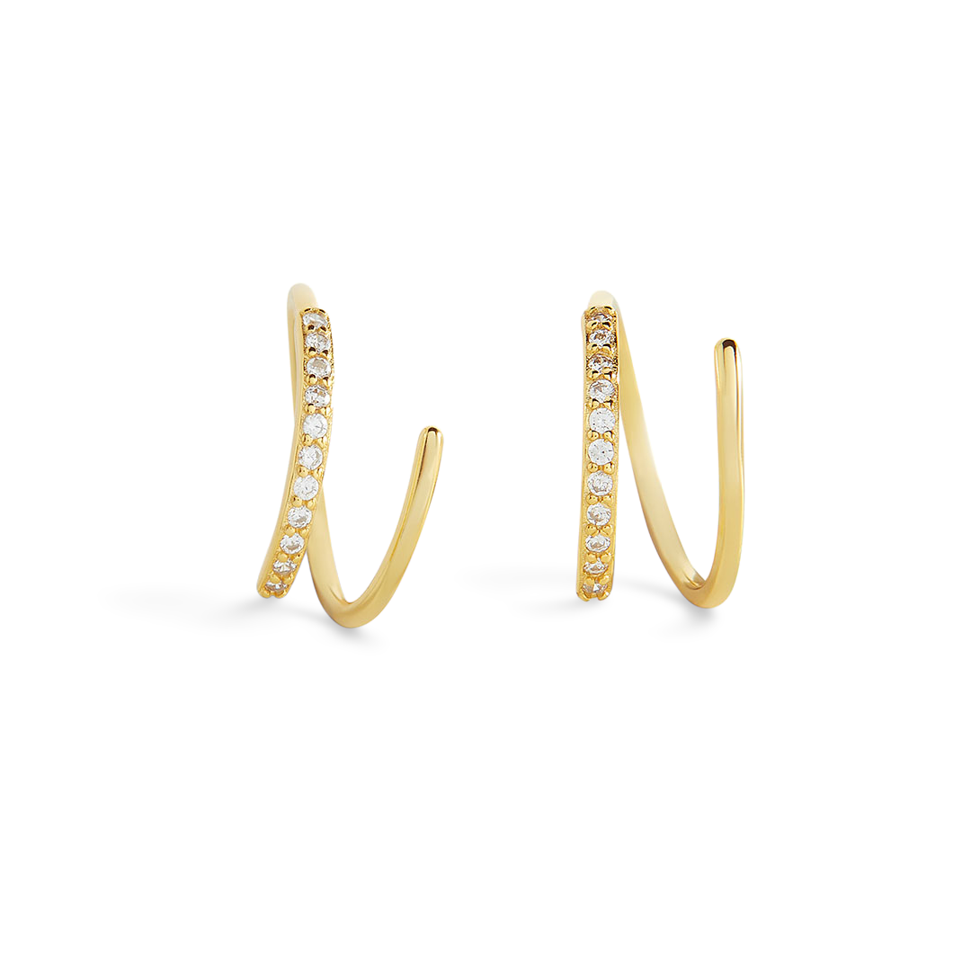 A pair of huggie hoop earrings with gold plating and embedded with 5A cubic zirconia stones on the loops.