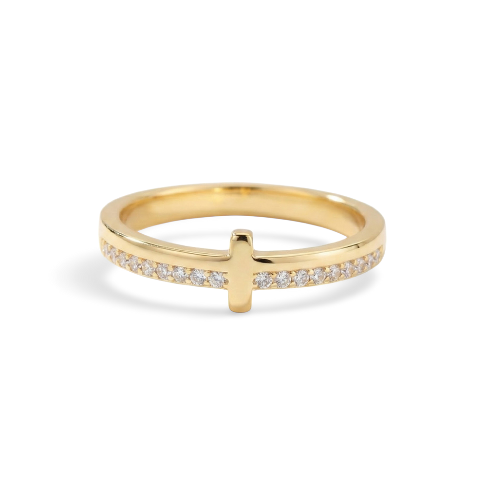 Gold ring with a cross design on a light gray background