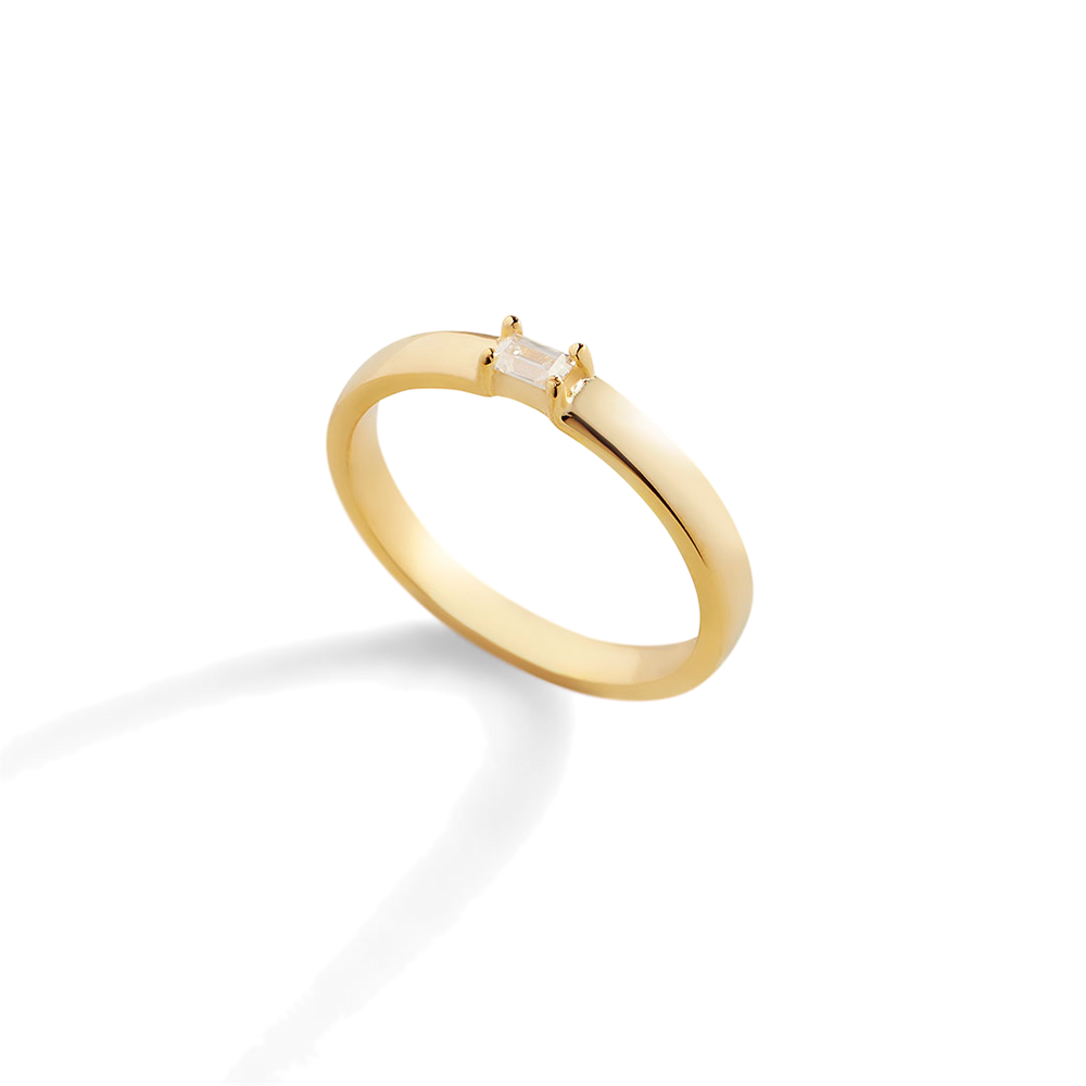 Gold ring with a small diamond on a light gray background