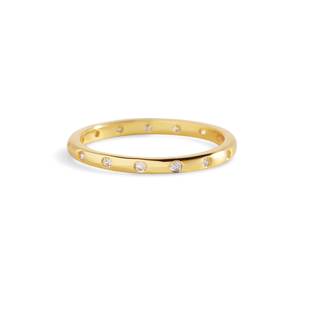 Gold ring with small diamonds on a light gray background
