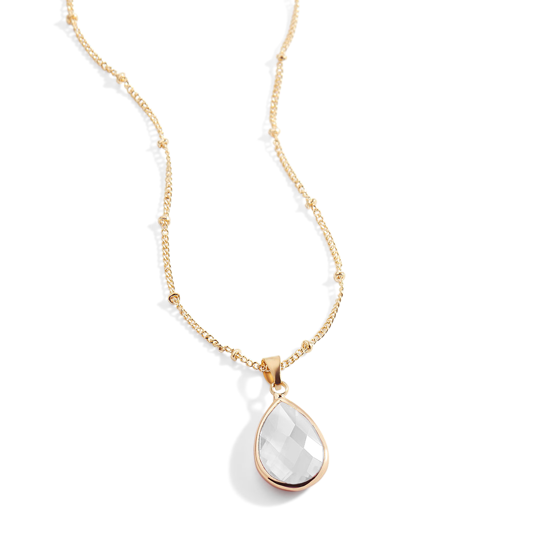 Gold necklace with a teardrop-shaped pendant on a light gray background
