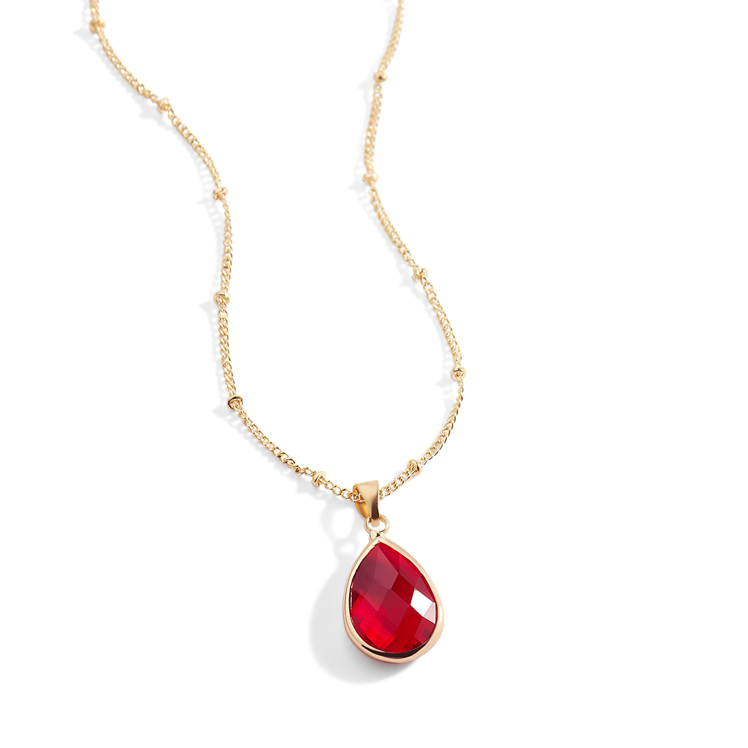 Gold necklace with a red teardrop pendant on a white background