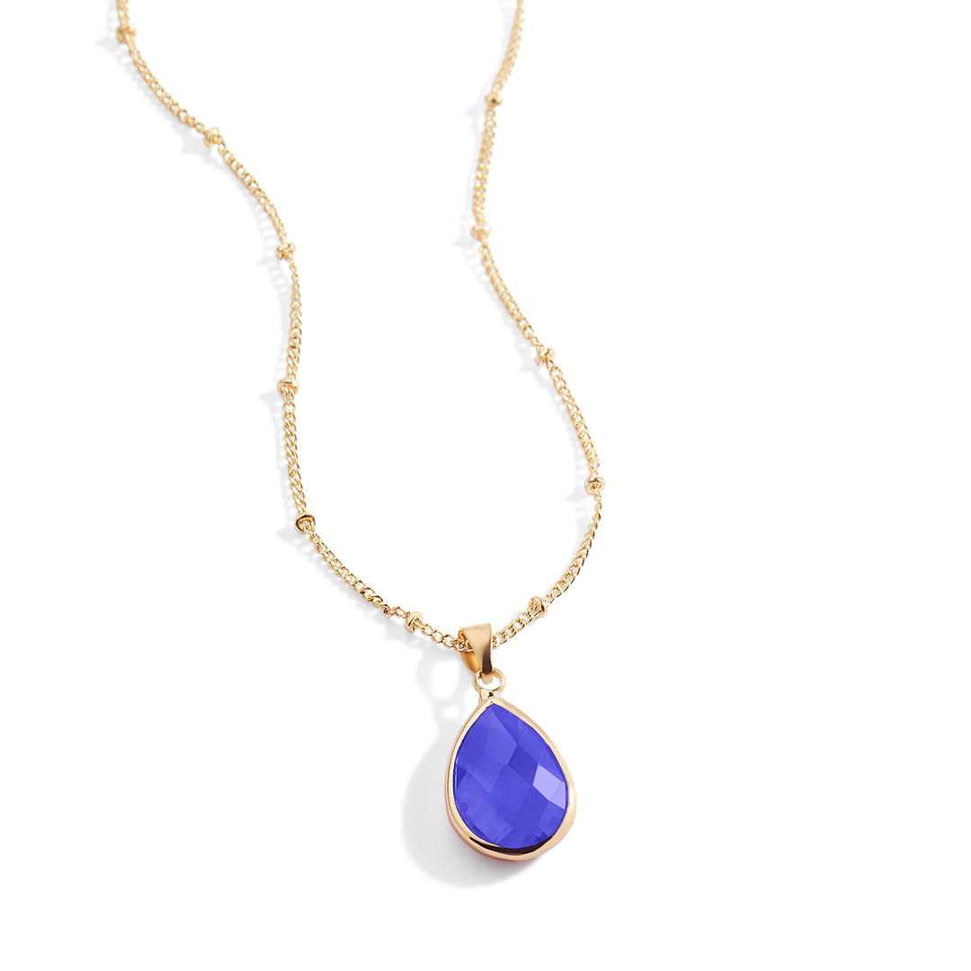 Gold necklace with a purple teardrop pendant on a white background