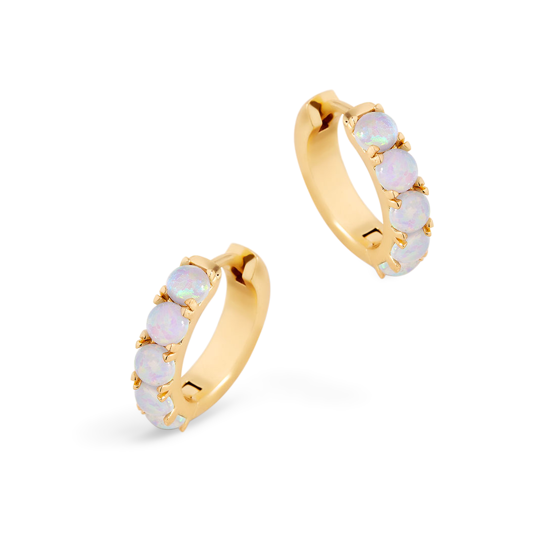 Gold hoop earrings with opal stones on a white background