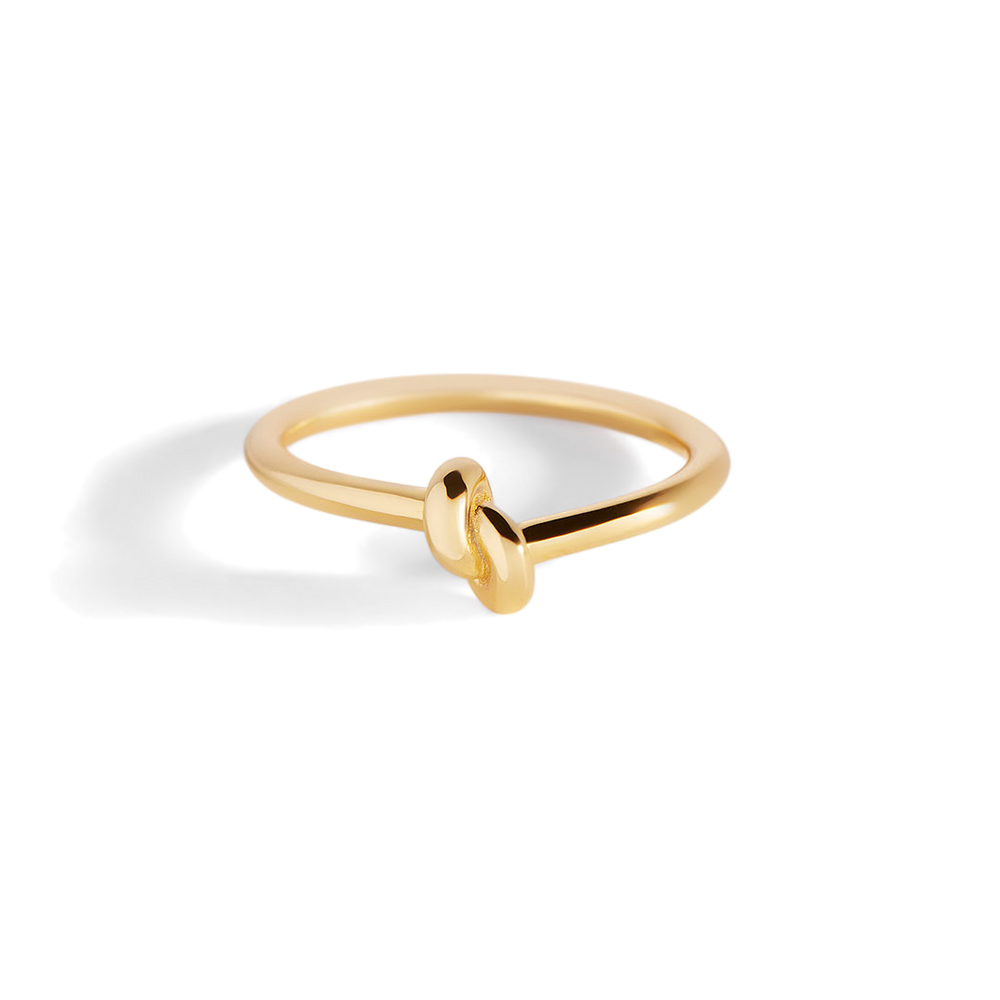 Gold ring with a unique design on a light gray background