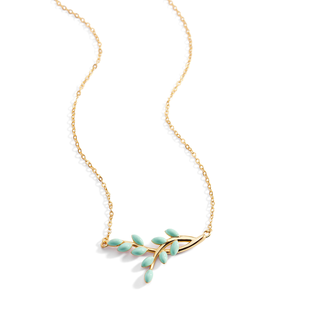 Gold necklace with green leaf pendants on a white background