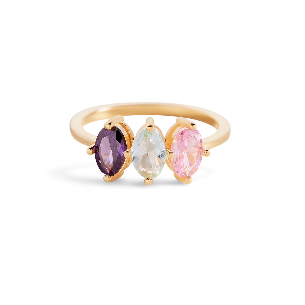 Gold ring with three colorful gemstones on a light gray background