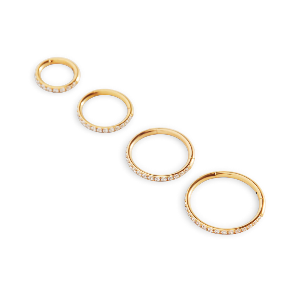Set of gold hoop earrings on a light gray background