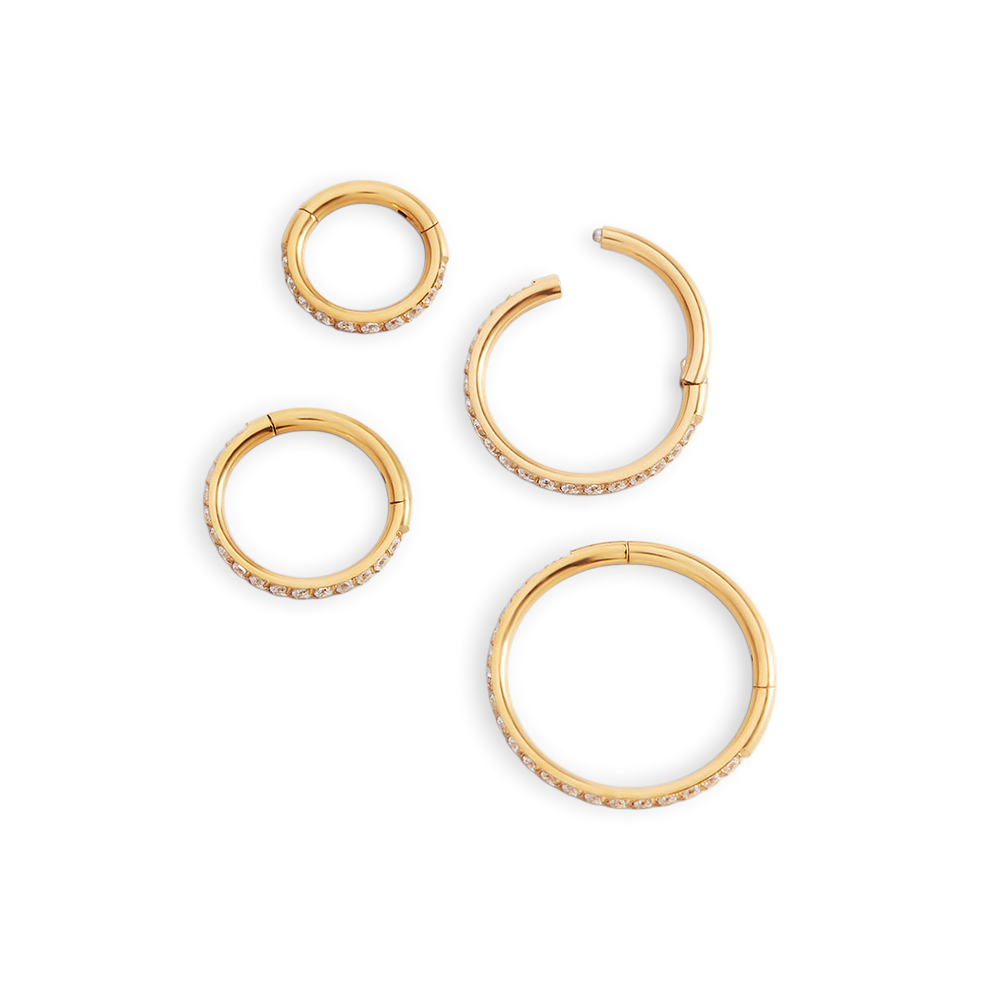Set of gold hoop earrings on a light gray background