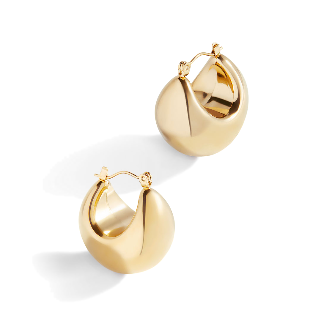 A pair of gold-colored sculpted hoop earrings against a white background.