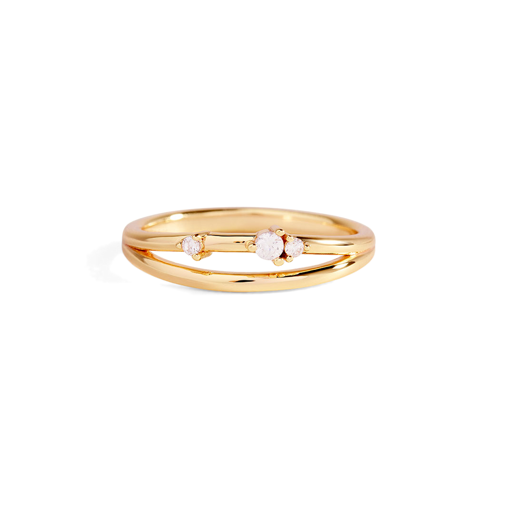 Gold ring with three small diamonds on a light gray background