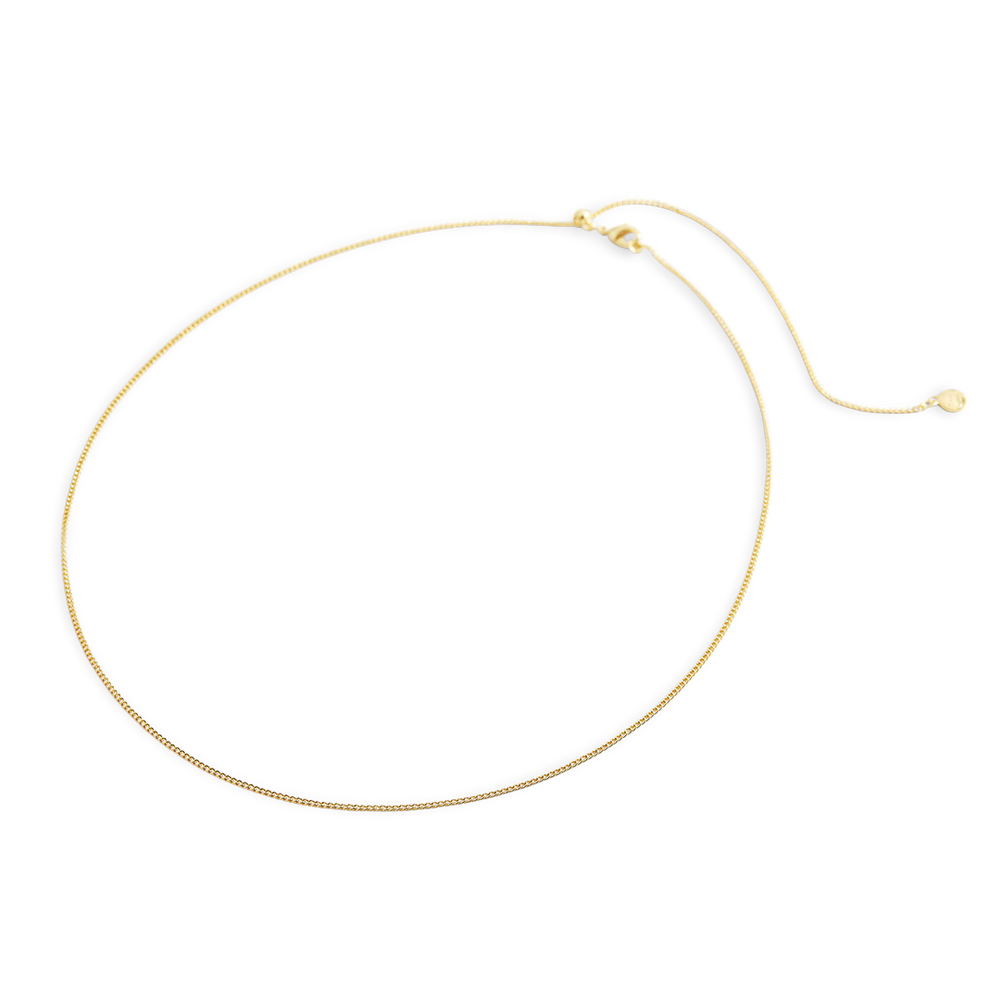 Gold necklace on a light gray background
