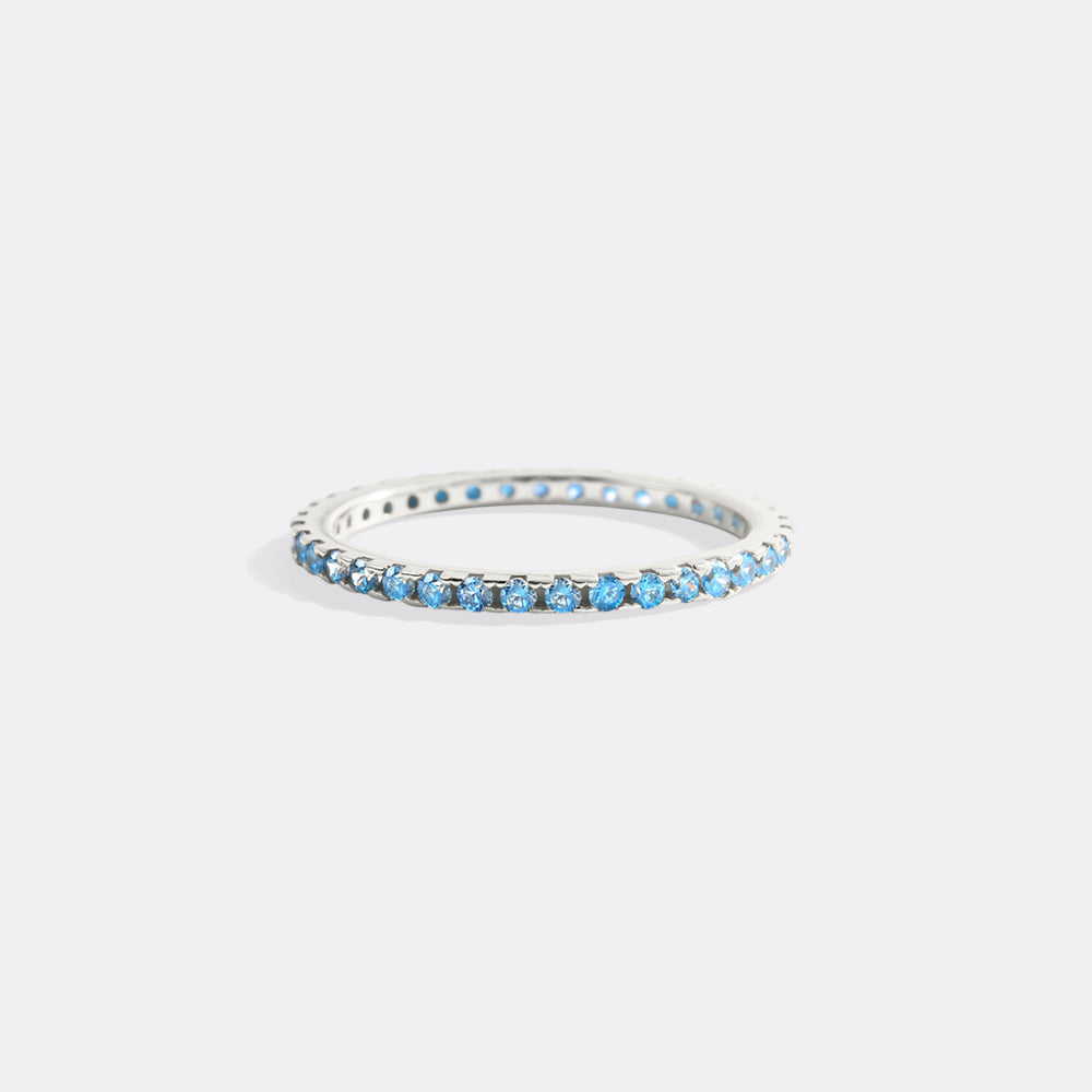 Silver ring with blue stones on a light gray background
