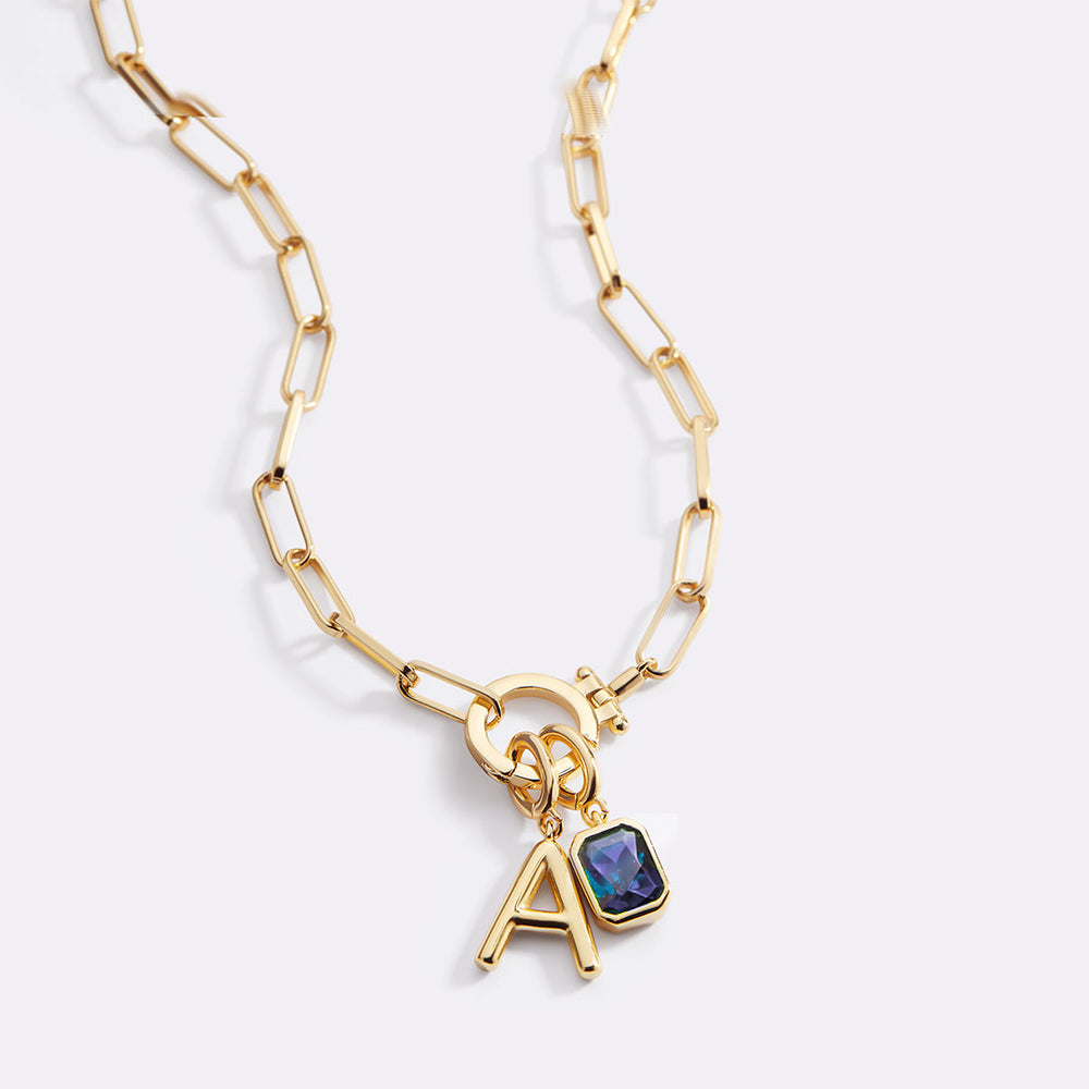Gold necklace with a letter 'A' pendant on a white background