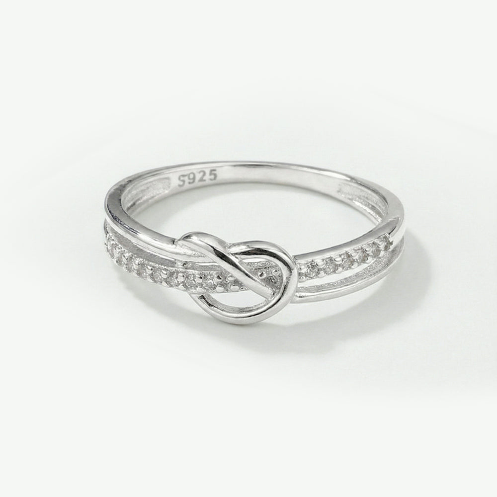 Silver ring with a knot design on a white background