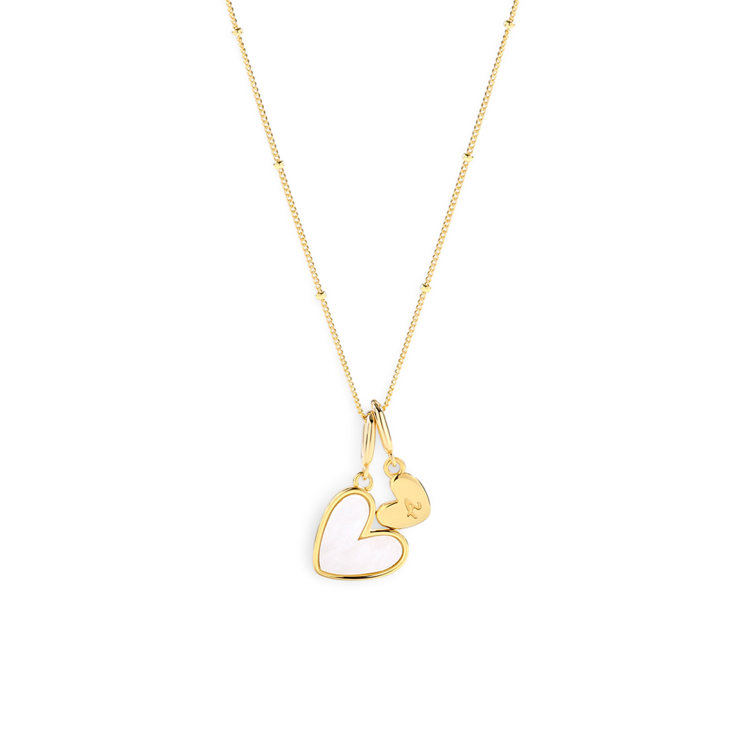 Gold necklace with a heart-shaped pendant on a light gray background