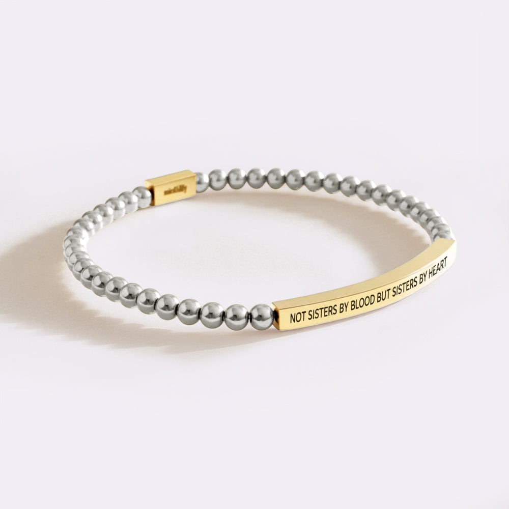 Bracelet with gold tag and gray beads on a white background