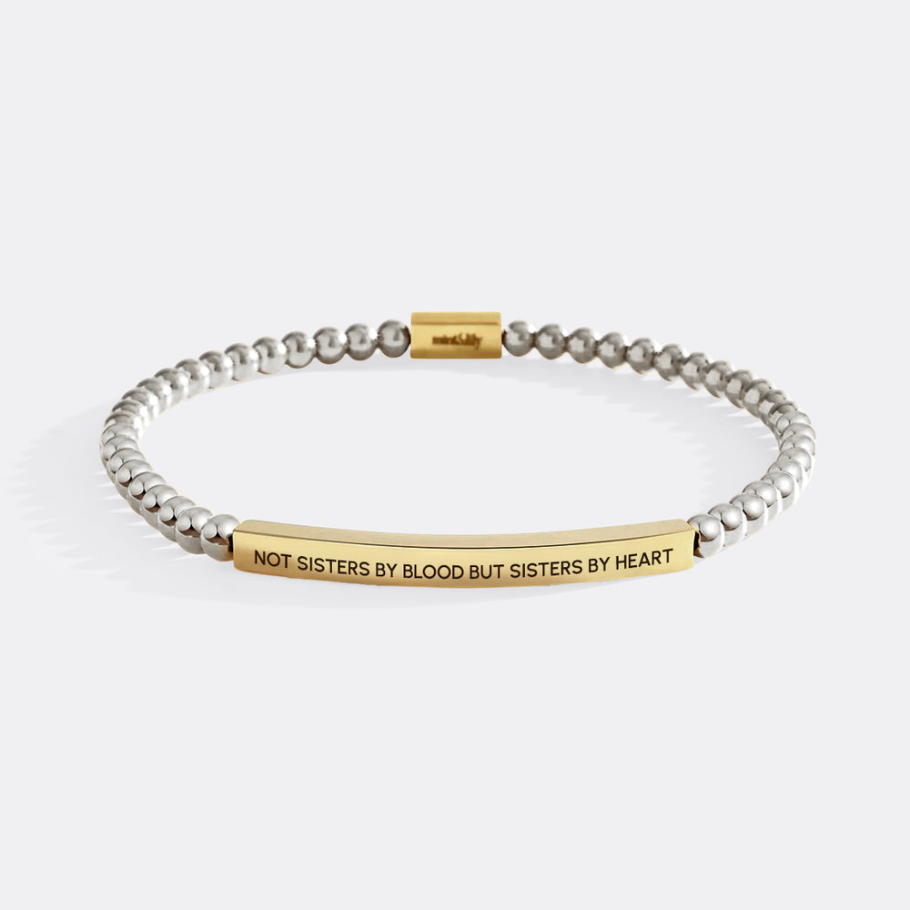 Bracelet with gold and silver beads and engraved message on a white background
