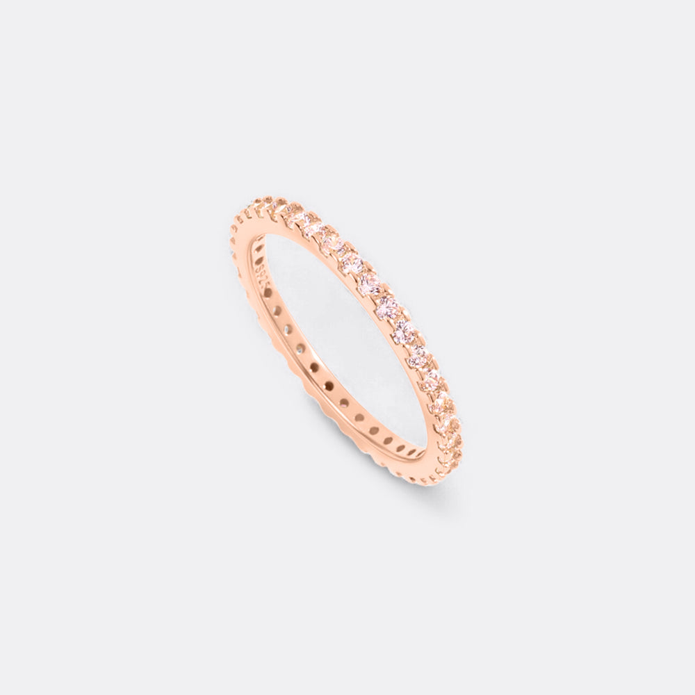Rose gold ring with small diamonds on a light gray background