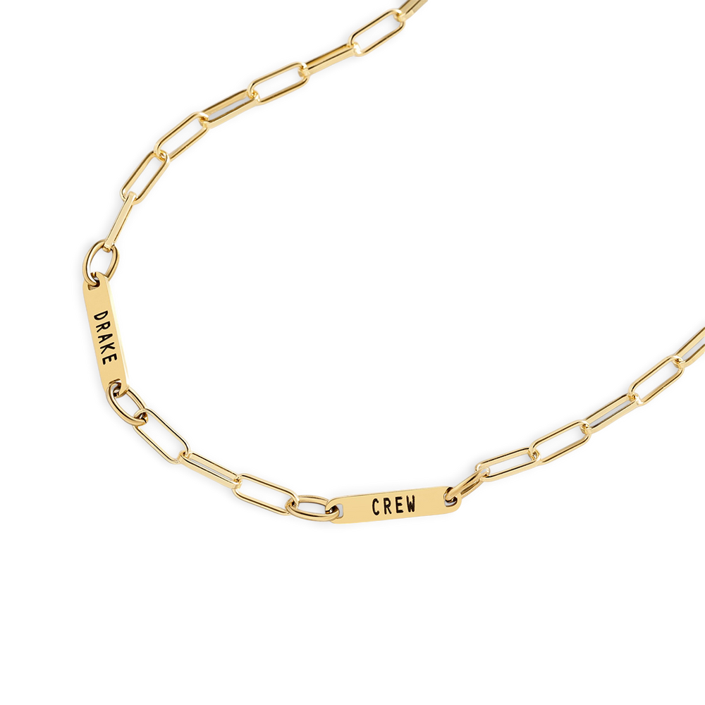 Gold chain bracelet with engraved names on a white background