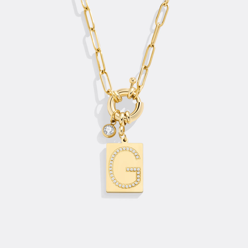 Gold necklace with letter 'G' pendant on a white background