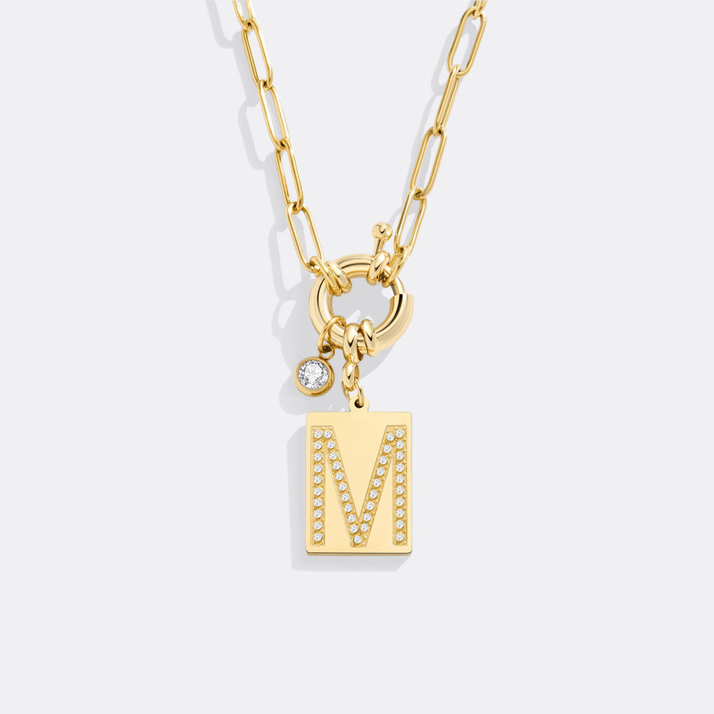 Gold necklace with a 'M' pendant on a white background