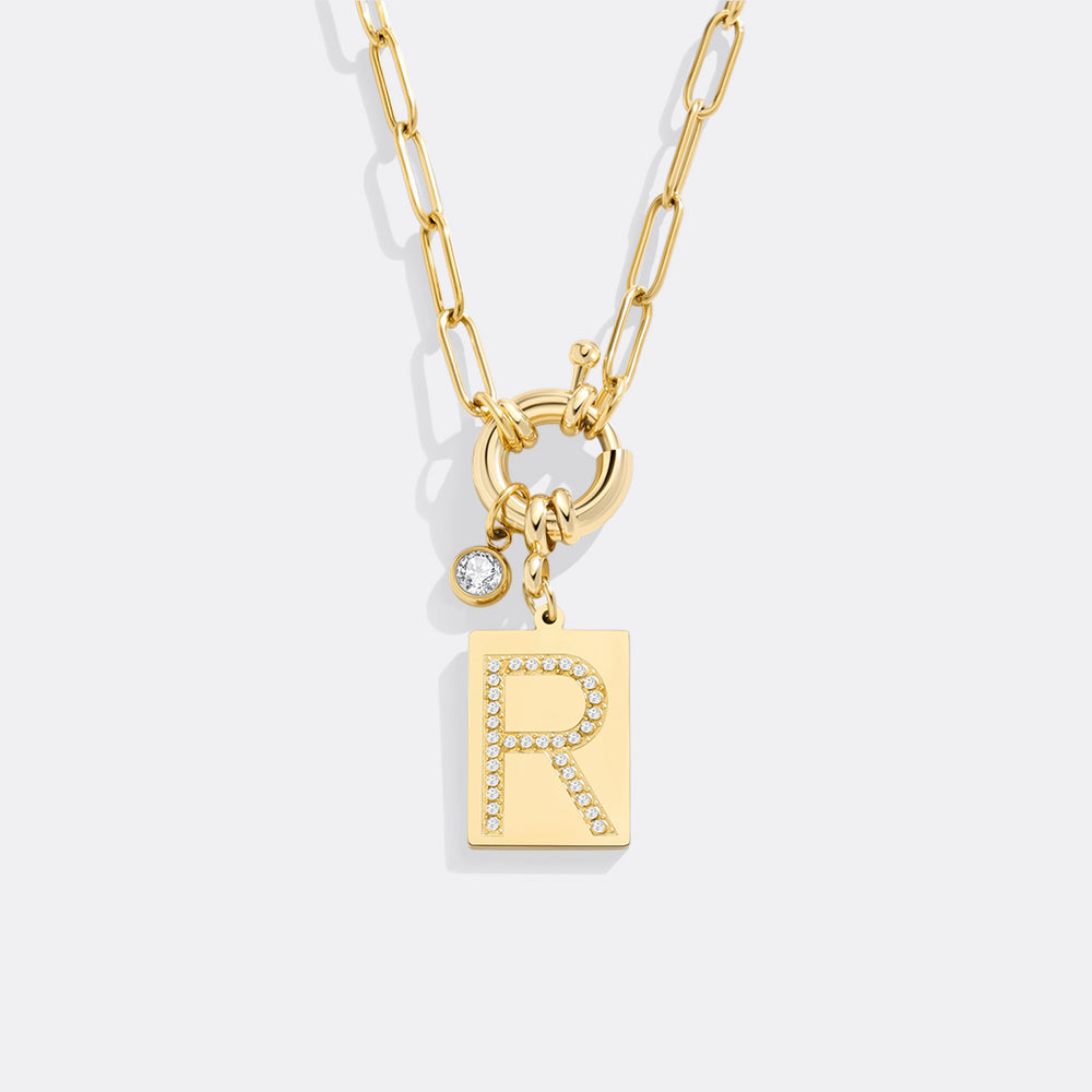 Gold necklace with letter 'R' pendant on a white background