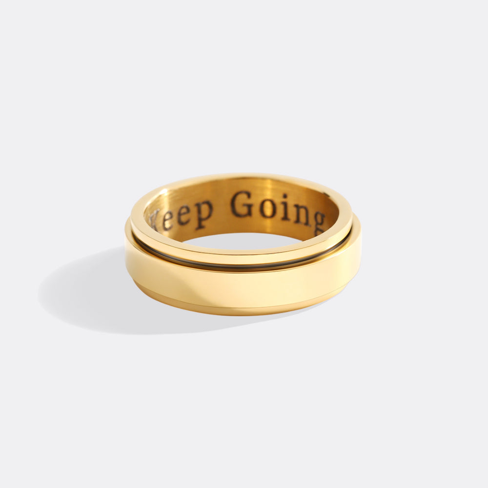 Gold ring with 'Keep Going' engraving on a white background