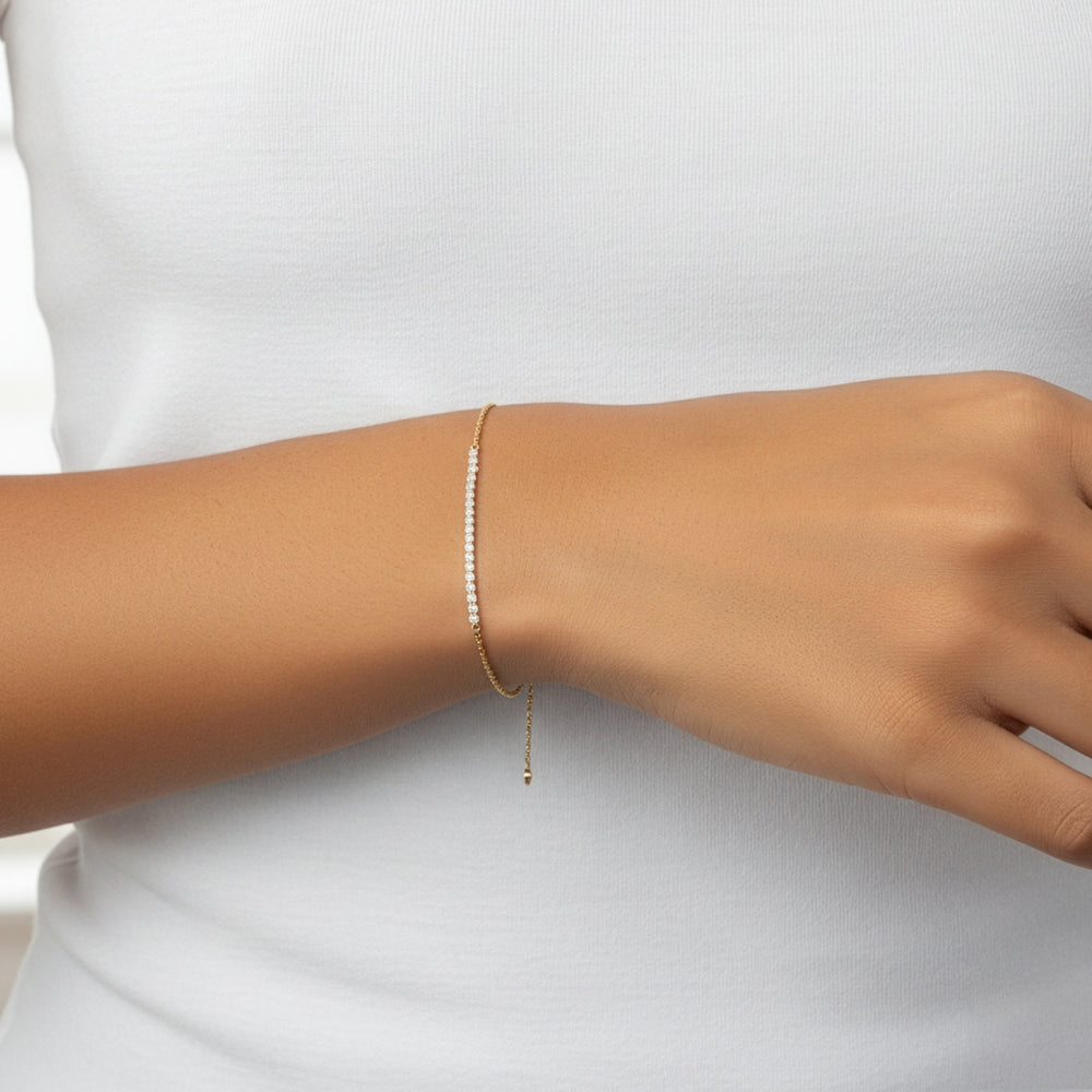 Model wearing the gold petite line bracelet on her wrist with a white t-shirt.